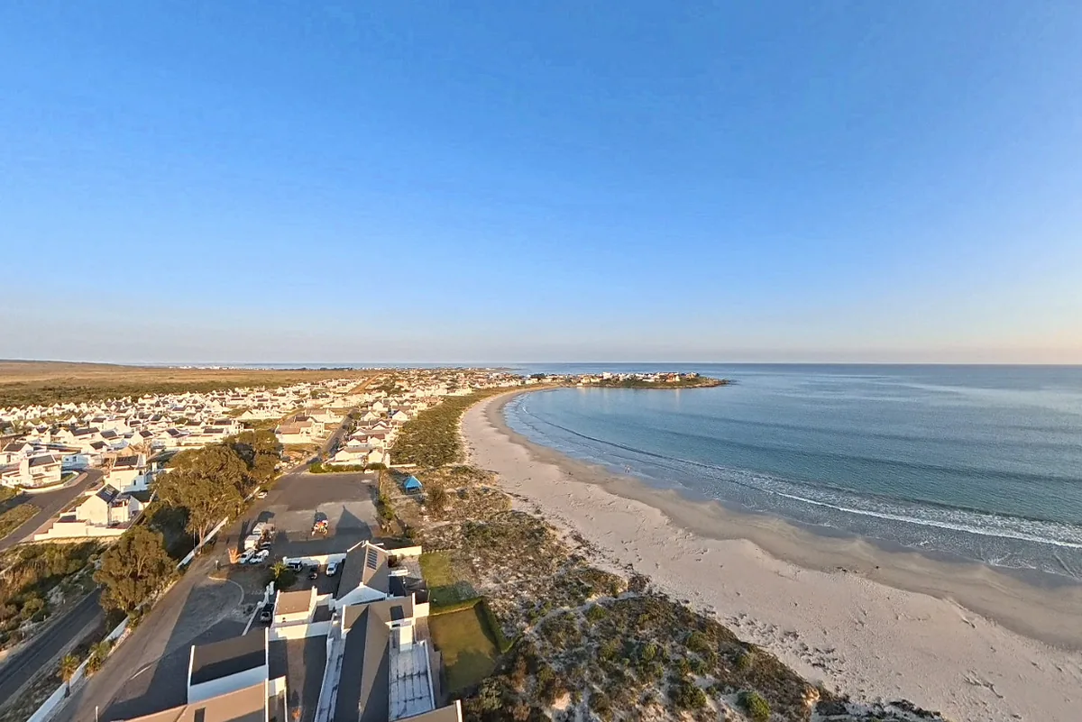 Aerial view of the Golden Mile from above Britannia Beach Estate, white houses along the dunes and the curve of St Helena Bay.