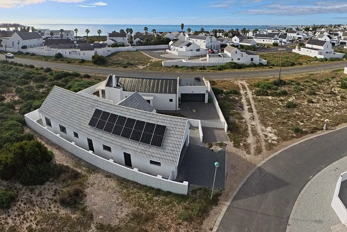 Aerial view of Five Fires in Britannia Beach Estate: a white West Coast house with solar panels, a walled courtyard and the Atlantic beyond the Golden Mile.