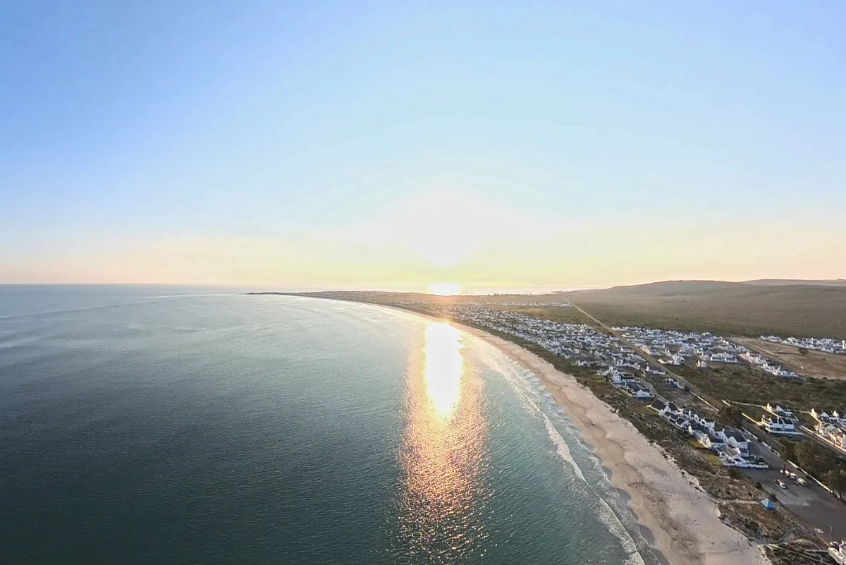 Sunrise over the Golden Mile at St Helena Bay, light on the water and the white houses along the shore.